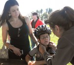 bike helmet A youngster gets properly fitted with a new bicycle helmet as his mother looks on at a recent Oswego Lions event at Fort Ontario.