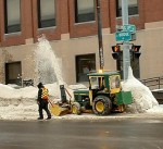snow_blowijng e 2 and bridge Workers clear snow from the sidewalk at East Second and Bridge streets area during a previous winter.