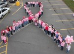 Human_Ribbon Nearly 100 community members gathered in the parking lot of the Fulton Price Chopper, dressed in pink, to raise awareness of breast cancer. The group formed a human pink ribbon in recognition of October being Breast Cancer Awareness Month.