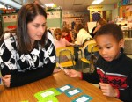 KPS JVBB Math_(6) Isaiah Henson finds the winning combinations as he played a Math game with Oswego jayvee girls’ basketball coach (and AIS Math teacher) Jessica Tremblay.