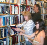 Backstreet_Vols Volunteers help place some new arrivals on the shelf at Backstreet Books & Bistro. In the foreground are Tessie Miner and her daughter, Valeree Miner. In the background is Steve Zink.