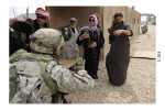 A member of the 1st Armored Division, Fort Bliss, encounters a group of local villagers during a training scenario at the National Training Center at Fort Irwin, Calif. Iraqis and other civilians are hired to bring a realistic feel to training. Many of the role players and staff live in the mock villages for the two week training exercise. (Photo by Staff Sgt. Christopher Griffin)