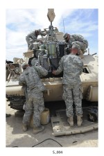 Members of the 1st Armored Division from Fort Bliss put an engine back into a Bradley armored fighting vehicle after replacing the transmission. The team spent two weeks at the National Training Center at Fort Irwin, Calif., working and living in austere conditions to prepare for an upcoming deployment to the Middle East. (Photo by Staff Sgt. Christopher Griffin)