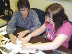 Scrapbooking Session Scrapbooking enthusiast, Pam Marion (left) assists Kennedy Myers of Mexico as she works on a holiday memory scrapbook project. Marion will facilitate a seminar on July 23 at the Oswego Public Library.