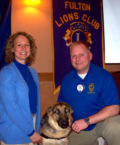 Cindy Swift, local coordinator for Guiding Eyes For The Blind guide dog school, was the featured speaker at the Fulton Lions Club March 28 meeting.  Swift and Roxanna, her dog in training, share a moment with Fulton Lions Club President David Dingman. The club donated $1,000 to the organization at the meeting and has been an annual contributor for many years. Guiding Eyes For The Blind is an internationally accredited guide dog school dedicated to enriching the lives of blind and visually impaired men and women. The Fulton Lions Club, also know for their Lions Loot Sweepstakes and Labor Day Duck Derby, provides financial assistance for those in need of eyeglasses, eye exams and hearing aids to residents in the Greater Fulton area.  The club is holding its first Comedy Night event at the Polish Home, on April 12. Tickets are available at Devine Designs and the Fulton Medicine Place. For further information on Fulton Lions: www.FultonLionsClub.org or visit the Fulton Lions Club page on Facebook®. For more information on Guiding Eyes visit www.guidingeyes.org.