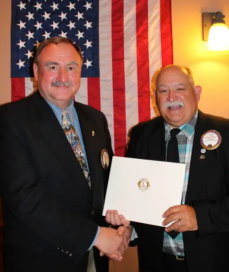 Fulton Lion Paul Foster, left, is congratulated on 40 years as a Fulton Lion by club President Don LaBarge. Foster, a past club president, deputy district governor, and two-time zone chairman, received a certificate of recognition for 40 years of service from Lions Clubs International President Barry J. Palmer. 