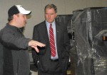 Jeremy Dygert, one of the owners of Champlain Valley Specialty, points out some of the new equipment at their new plant in Oswego Town to Congressman Bill Owens on Tuesday.