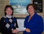 Diane Cooper-Currier (right), executive director of Oswego County Opportunities, receives a “Building Dreams” sponsorship from NRG regional administrative assistant Donna Moonan.