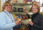 Helen Hoefer (left), supervisor of Community Services for Catholic Charities of Oswego County and Deb Deeb, director of Human Concerns in Oswego, fill the shelves of the food pantry at Human Concerns. While their respective food pantries are facing a record demand for food subsidy, the two are encouraged by the support they have been receiving from their communities.