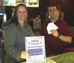 Carolyn Handville, coordinator of Oswego County Opportunities’ Cancer Services Program receives movie passes from Josh Gadek, manager of the Oswego Cinema. Throughout February, the program is offering free clinical breast exams, mammograms, pap/pelvic exams and colon cancer screenings to uninsured community members. Eligible couples that each complete at least one screening will receive a $25 gift certificate for dinner and two free movie passes to the Oswego Cinema.