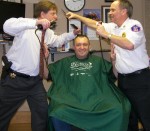 Doug Kells, owner of Doug’s Barbershop in Oswego and a veteran St. Baldrick’s volunteer barber, tries to keep peace between Oswego County Undersheriff Gene Sullivan (left) and Oswego City Fire Chief Jeff McCrobie. Make your donation today to support the cops, firefighters and the kids they’re helping. Visit http://www.stbaldricks.org/events/mypage/337/2012