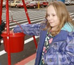 LeeLynn Shatraw puts a donation in one of the Salvation Army's kettles. She even helped ring the bell.